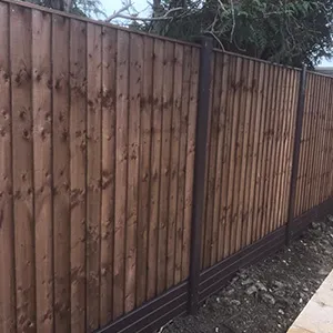 a wooden fence with a stone walkway next to it