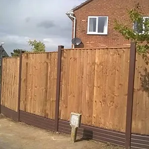 a wooden fence with a brick building in the background